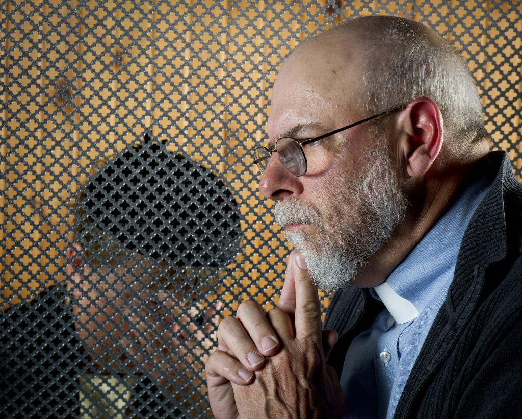 A priest is concerned with a woman in the confessional.